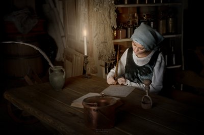 Mulher a escrever à luz de uma vela de Andrzej Lisowski