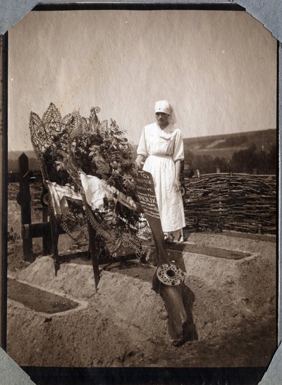 Primeira Guerra Mundial 1914-1918: enfermeira (Therese Pavillou?) numa blusa sobre o túmulo do sargento piloto francês Roux, morto aos 21 anos de idade, em Couville, Manche, Basse-Normandie (Baixa Normandia), França. Fotografia anónima de Julho de 1917. Co de Anonymous Anonymous