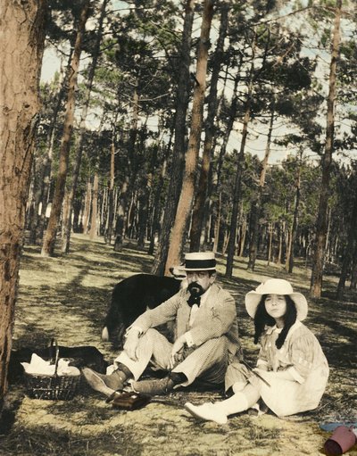 O compositor francês Claude Debussy (1862-1918) e sua filha Chouchou sentados para um piquenique em um pinede perto de Arcachon de Anonymous Anonymous