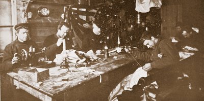 Na cabana durante o meio do Inverno, os homens que se dedicavam à costura de peles para vestuário a ser utilizado em trenós primaveris, pub. Londres 1907 (foto a p/b) de Anthony Fiala