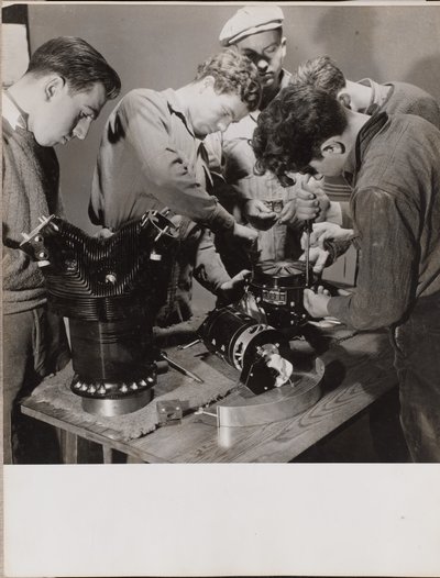 [Cinco jovens trabalham à volta de uma bancada de trabalho]. de Arnold Eagle