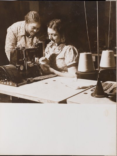[Duas mulheres utilizam uma máquina de costura]. de Arnold Eagle