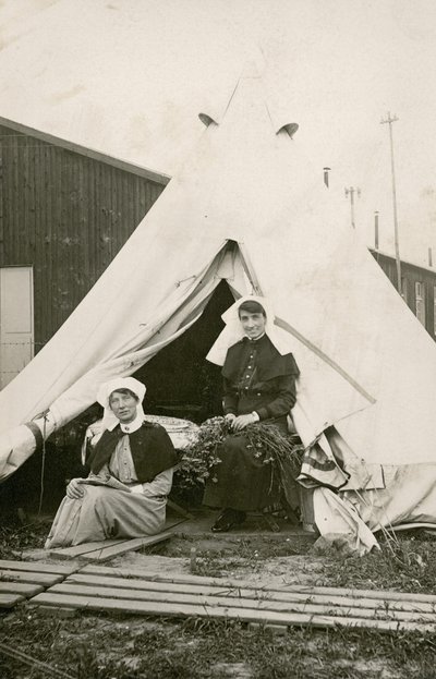 Irmã Eleanor Wibmer Jeffries e Irmã Nellie Constance Morrice (à direita) do lado de fora de sua tenda no número 3 do Hospital Geral Australiano com flores colhidas na margem do Somme, c. Junho de 1917 (foto do bw de Australian Photographer