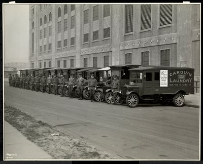 Uma linha de caminhões de entrega estacionados do lado de fora da lavanderia Carolyn, na 111 East 128th Street, East Harlem, Nova York, 1929 (impressão em gelatina de prata) de Byron Company