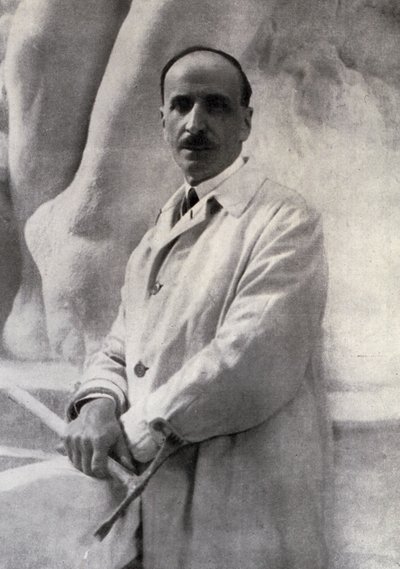 Retrato de três quartos do escultor Edoardo Rubino com martelina na mão. No fundo, um esboço pode ser feito de Carlo Gherlone