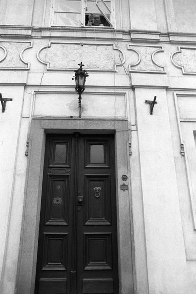Jiri Mucha abaixando uma chave em uma corda para que um visitante possa abrir as portas de sua casa em Hradcany, Praga de Czech Photographer