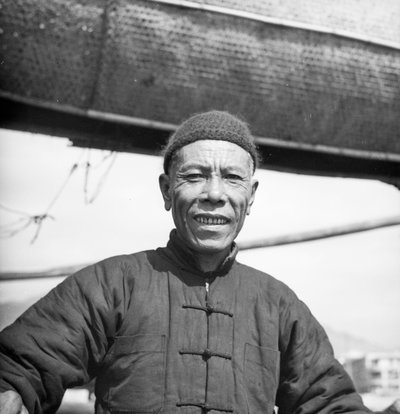 Retrato de um membro da tripulação de um junco de sal de Cantão a bordo do seu navio em Sham Shui Po, Hong Kong de David Watkin Waters