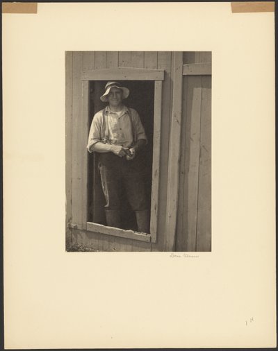 [Homem de chapéu de palha à porta de um celeiro, segurando uma bolsa de tabaco] de Doris Ulmann
