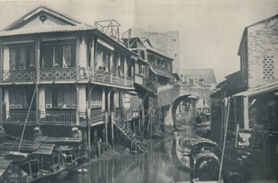 Águas contaminadas sob uma ponte que conduz a casas desagradáveis de pobreza e dor, c1935 de ENA