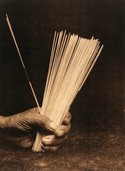 Grande plano da mão de um índio da tribo ou aldeia Hupa segurando varas de adivinhação de Edward Sheriff Curtis