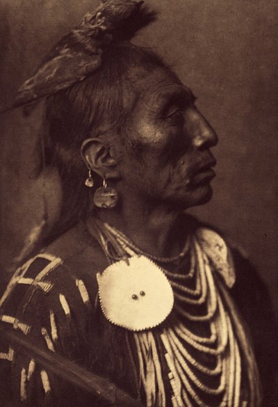 Medicine Crow, Apsaroke. O falcão amarrado à sua cabeça é uma forma de carregar o símbolo do seu espírito protector. Foto tirada do volume 4 da enciclopédia publicada por Edward S. Curtis (1868-1952) sobre os índios da América do Norte, com um prefácio de  de Edward Sheriff Curtis