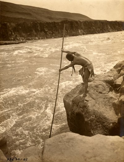 Índio Tlakluit, de pé sobre uma rocha, a pescar com rede de mergulho, c.1910 (fotografia a preto e branco) de Edward Sheriff Curtis