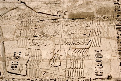 Antiquidade egípcia: detalhe dos relevos da primeira torre representando a captura de combatentes pertencentes aos povos do mar, inimigos de Ramsés III. Templo Funerário de Ramsés III (1187-1156 AC). Luxor, Medinet Habou, Egito. de Egyptian 20th Dynasty