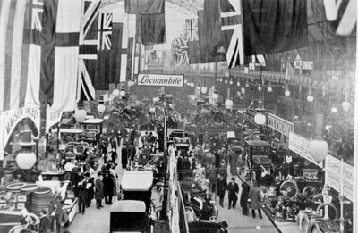 Visão geral das multidões que inspecionam as exposições em um salão do automóvel de English Photographer