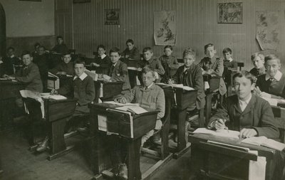 Alunos masculinos sentado atrás de suas mesas durante uma aula na escola de English Photographer