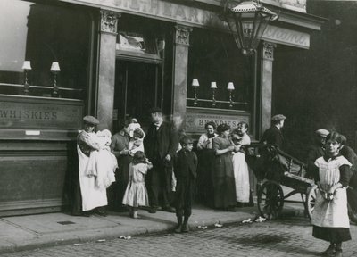 Homens, mulheres e crianças fora de uma taverna de Londres de English Photographer