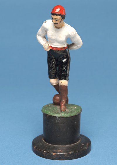 Jogador de futebol com a bola a seus pés (metal pintado à mão) de English School