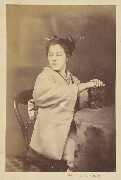 [Mulher japonesa sentada segurando um álbum de cartes-de-visite numa mesa] de Felice Beato