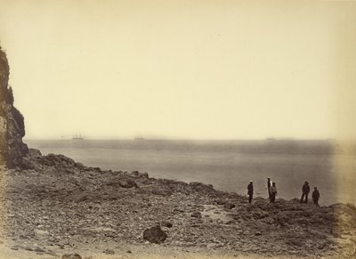 [Vista da costa com navios no horizonte e cinco figuras de pé na praia]. de Felice Beato