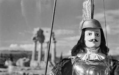 Marioneta siciliana. Em segundo plano, o Templo de Castor e Pólux ou Castor e Pólux no Vale dos Templos em Agrigento de Fosco Maraini