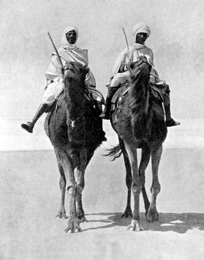 Dois árabes montando camelos no deserto do Saara, na África, 1936. de Fox Photos