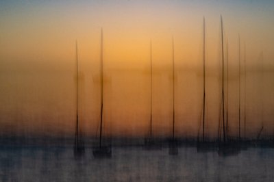 Veleiros ao pôr-do-sol desfocados de Franco Tessarolo