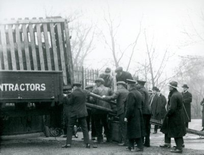 Uma multidão de espectadores espera enquanto um rinoceronte é descarregado de um caminhão, por guardiões, no zoológico de Londres em 1924 de Frederick William Bond