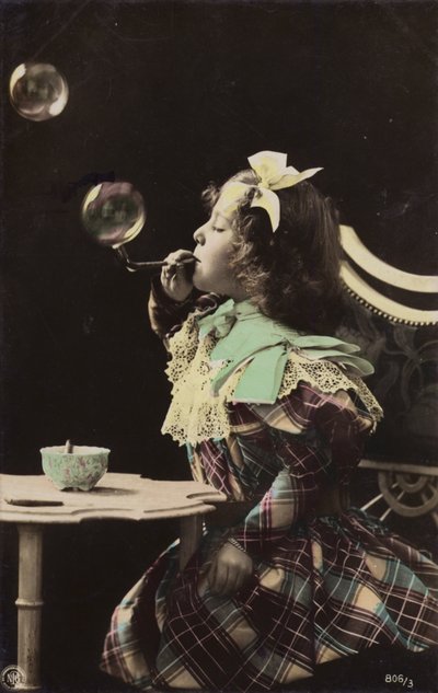Uma menina soprando bolhas de um cano (foto matizada) de French Photographer