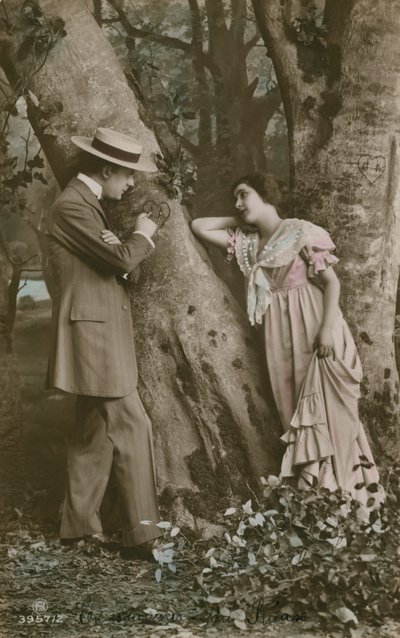 Postal de amantes que esculpem um coração em uma árvore, enviado em 1913 (foto colorida à mão) de French Photographer