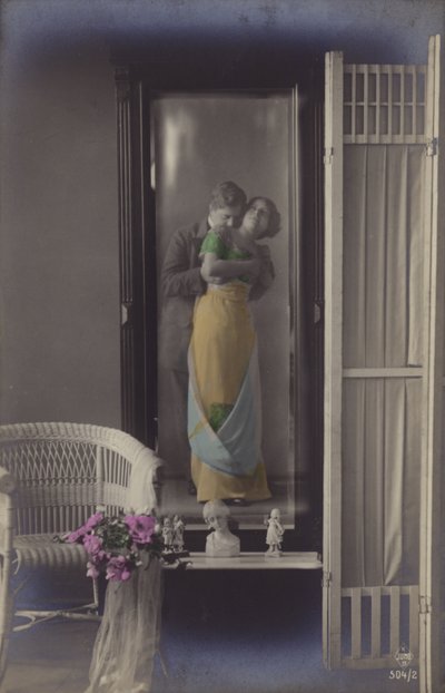 O reflexo em um espelho de um jovem casal se beijando (foto matizada) de French Photographer