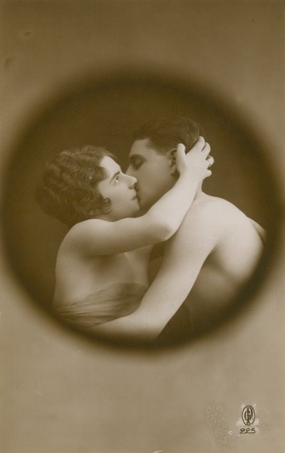 Homem novo e mulher que beijam como vistos através de um peephole. Postal enviado em 1913. de French Photographer
