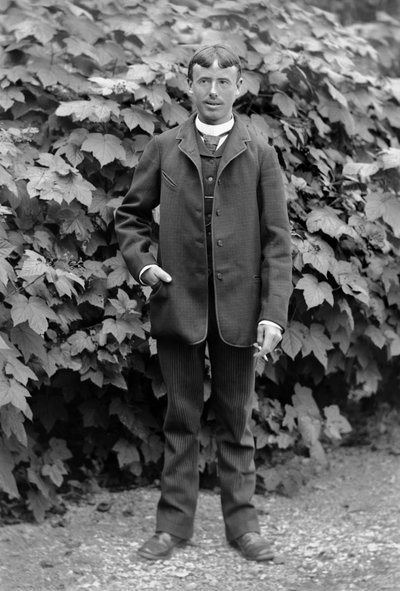 O jovem tem um cigarro, empregado como homem para fazer tudo, posando no jardim da Abadia de Septfontaines, perto de Bourmont em Haute-Marne (Haute Marne), por volta de 1880. Fotografia. Coleção Ducos. de French Photographer
