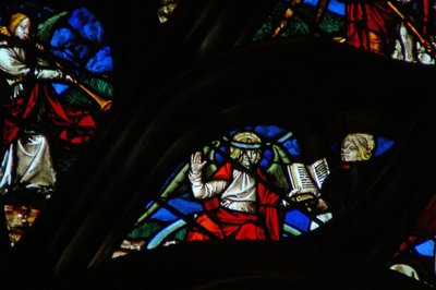 A janela rosa do oeste representando uma cena do livro do Apocalipse: um anjo (em um arco-íris) dando a São João um livro aberto (10: 1,8). de French School