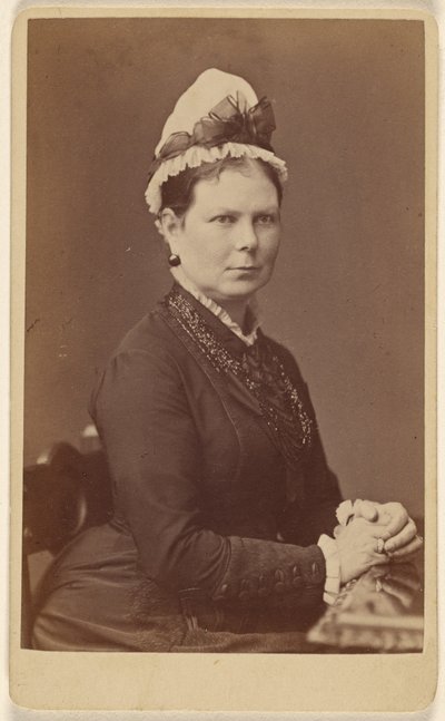 Mulher não identificada com touca de laço, sentada com as mãos juntas de George Washington Wilson