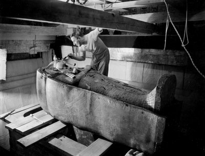 Descoberta do túmulo do faraó Tutankhamun no Vale dos Reis (Egipto) : em câmara funerária, Howard Carter trabalhando na tampa do segundo caixão, outubro de 1925, foto de Harry Burton (p1568) de Harry Burton
