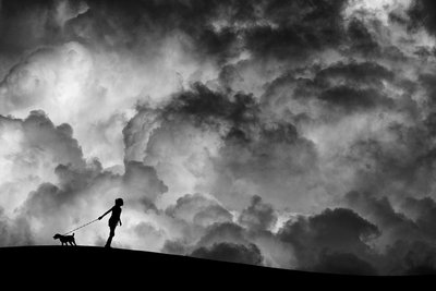 Passeio com o cão sob um céu tempestuoso de Hengki Lee