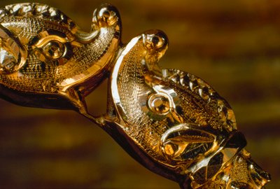 Uma pulseira de ouro trabalhada à mão apresenta duas cabeças de tubarão em colisão. América do Sul. de James L Stanfield