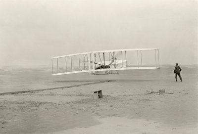 O Wright Flyer I faz o seu primeiro voo de 120 pés em 12 segundos, em Kitty Hawk, Carolina do Norte de John T. Daniels