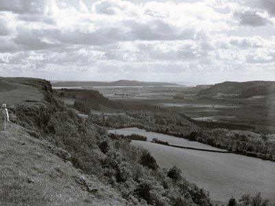 Uma senhora está numa encosta a olhar para a paisagem de Scout Scar de Joseph Hardman