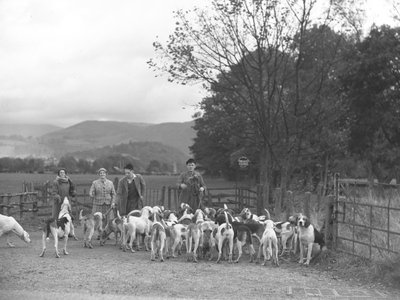 Dois homens e duas mulheres estão de pé com um grupo de cães de caça de Joseph Hardman
