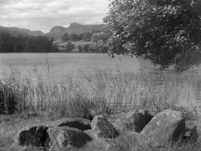Vista de Loughrigg Tarn, em primeiro plano estão algumas pedras colocadas no chão de Joseph Hardman