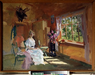 Na Sala. Uma jovem mulher com um vestido de cor clara, sentada em frente a uma janela, através da qual o jardim pode ser visto no Verão. Pintura de Konstantin Alexeyevich Korovin (1861-1939), óleo sobre tela de Konstantin Alekseevich Korovin