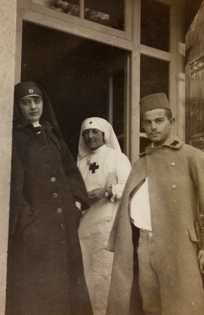 Álbum da Primeira Guerra Mundial em Friuli-Venezia Giulia: Retrato de duas enfermeiras da Cruz Vermelha com um cadete prisioneiro austríaco na Villa Brazzà, casa de 17 do Hospital de guerra em Soleschiano Manzano (foto a p/b) de L. Verdiani