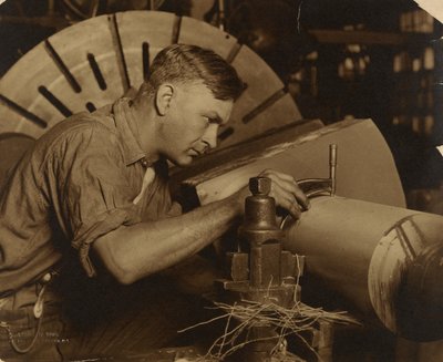 Homem com micrómetro a medir um veio ao milésimo de polegada. de Lewis W. Hine