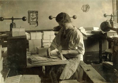 Uma rapariga de 15 anos corta moldes na loja de estampagem de Harry C. Taylor, 61 Court Street, em Boston, Massachusetts de Lewis Wickes Hine