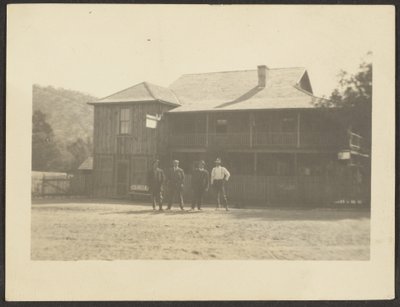 [Quatro homens diante de um edifício de madeira]. de Louis Fleckenstein
