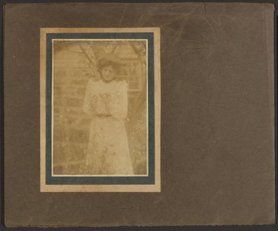 [Mulher a segurar uma flor no jardim]. de Louis Fleckenstein
