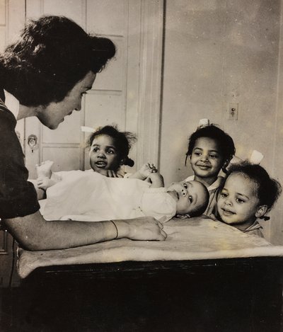 O enfermeiro Henry Street presta assistência a três raparigas afro-americanas no Harlem, em Nova Iorque de Luigi Leoni