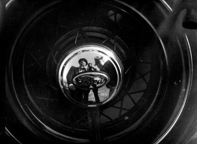 Algumas pessoas reflectem-se numa calota de um Ford de Luigi Leoni