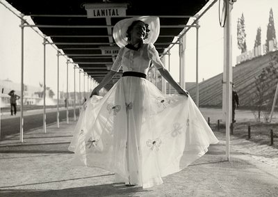 Modelo com um vestido de verão completo criado pela casa de alta costura "Graldi". O vestido é de tecido leve decorado com bordado; um chapéu de aba larga completa o conjunto. (foto a p/b) de Luis Bogino